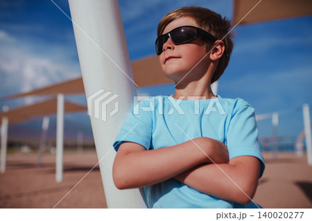 Portrait of handsome boy with sunglasses on the beach Portrait of handsome boy with sunglasses on the beach 140020277