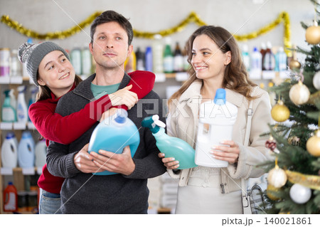 Father, mother and daughter choose detergent in supermarket Father, mother and daughter choose detergent in supermarket 140021861