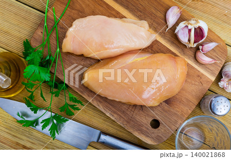 Raw chicken breast fillet served with parsley Raw chicken breast fillet served with parsley 140021868