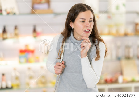 In perfume shop, girl customer stares at windows. In perfume shop, girl customer stares at windows. 140021877