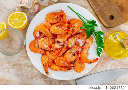 Delicious seafood dish, shrimps served with parsley and lemon Delicious seafood dish, shrimps served with parsley and lemon 140021882