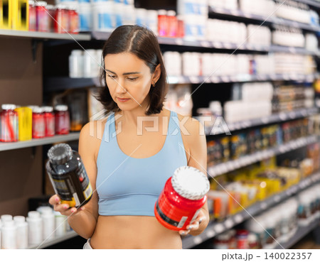 Woman chooses protein sports nutrition in store 140022357