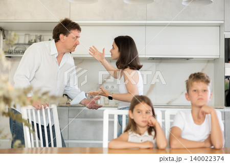 Kids feels upset while parents quarrel at background. Little girl and boy frustrated with psychological problem caused by mom and dad arguing, family conflicts or divorce impact on child concept Kids feels upset while parents quarrel at background. Little girl and boy frustrated with psychological problem caused by mom and dad arguing, family conflicts or divorce impact on child concept 140022374
