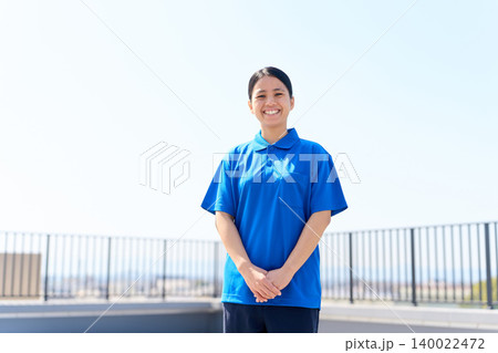 青空を背景に立つ外国人女性介護士 青空を背景に立つ外国人女性介護士 140022472