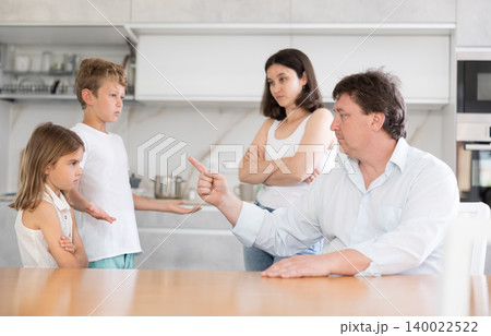 Father and mother, scolding little son and daughter for disobedience 140022522