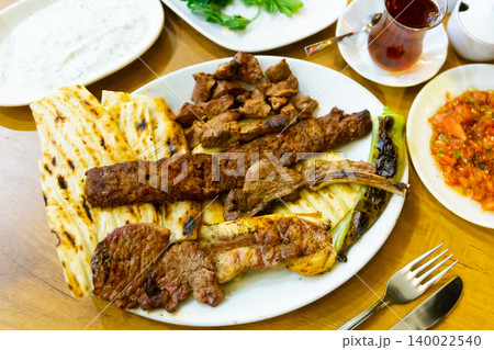 Plate with fried meat, pita bread and stewed peppers. Turkish cuisine Plate with fried meat, pita bread and stewed peppers. Turkish cuisine 140022540