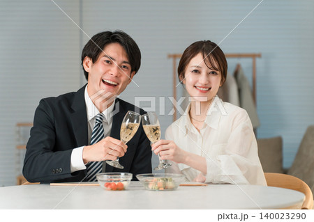 自宅のダイニングテーブルでシャンパン,スパークリングワインを飲む笑顔の夫婦,カップル 自宅のダイニングテーブルでシャンパン,スパークリングワインを飲む笑顔の夫婦,カップル 140023290