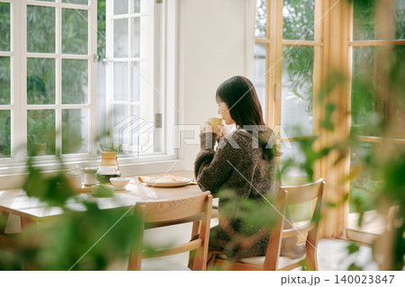 朝食を楽しむ一人暮らしの女性 朝食を楽しむ一人暮らしの女性 140023847