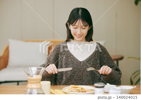 手作りの朝食を楽しむ一人暮らしの女性 手作りの朝食を楽しむ一人暮らしの女性 140024015