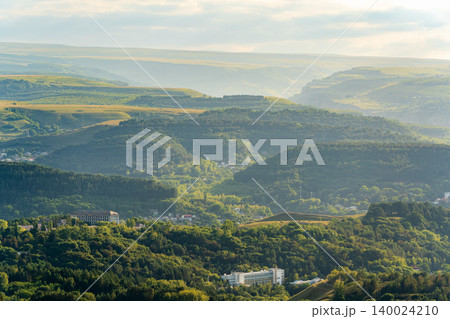 Layers of green mountains and hills in the haze during sunset. Panoramic View of Green hills and Meadow. Layers of green mountains and hills in the haze during sunset. Panoramic View of Green hills and Meadow. 140024210