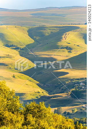 Layers of green mountains and hills in the haze during sunset. Panoramic View of Green hills and Meadow. Layers of green mountains and hills in the haze during sunset. Panoramic View of Green hills and Meadow. 140024213