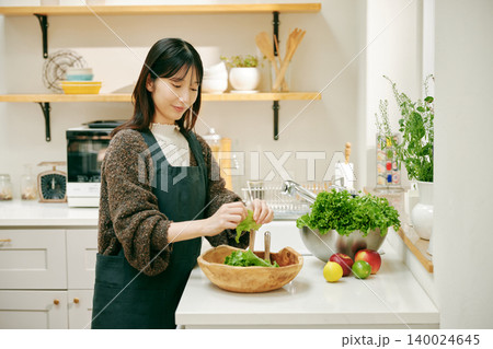 新鮮な野菜を使って料理をする女性 新鮮な野菜を使って料理をする女性 140024645