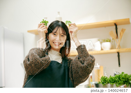 新鮮な野菜を使って料理をする女性 140024657