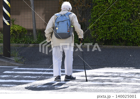 日本の横浜都市景観横断歩道を渡る杖の高齢男性(マスク姿)。黒い影が横断歩道に揺れる…人生とは… 日本の横浜都市景観横断歩道を渡る杖の高齢男性(マスク姿)。黒い影が横断歩道に揺れる…人生とは… 140025001