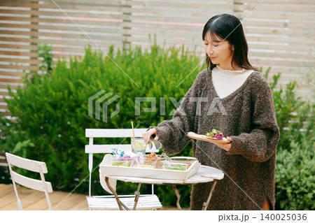 庭でタコスを食べる女性 140025036