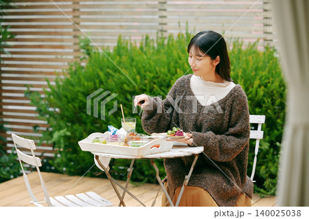 庭でタコスを食べる女性 140025038