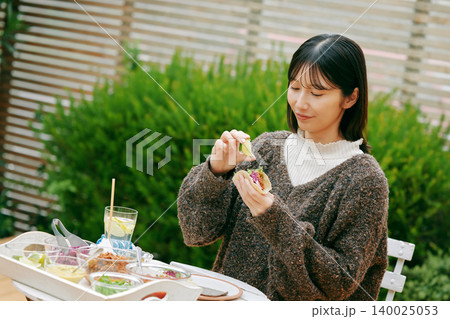 庭でタコスを食べる女性 庭でタコスを食べる女性 140025053