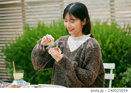 庭でタコスを食べる女性 140025054