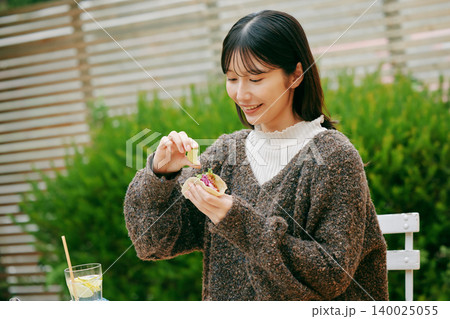 庭でタコスを食べる女性 140025055
