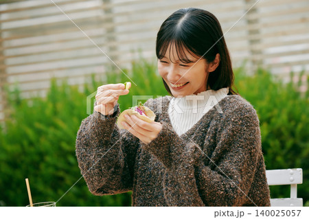 庭でタコスを食べる女性 庭でタコスを食べる女性 140025057