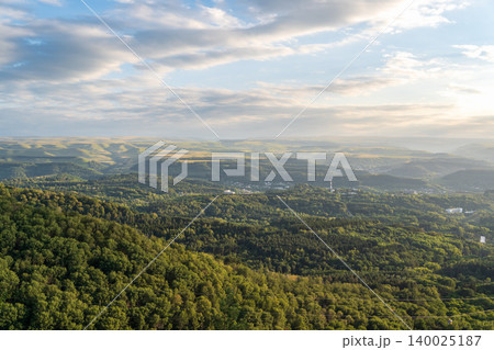 Layers of green mountains and hills in the haze during sunset. Panoramic View of Green hills and Meadow. Layers of green mountains and hills in the haze during sunset. Panoramic View of Green hills and Meadow. 140025187