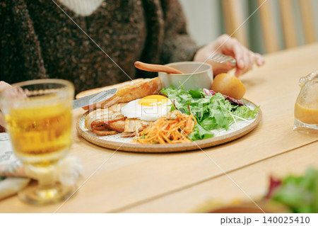 ワンプレート朝食を食べる女性の手元 140025410