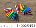 木のテーブルに並べた色鉛筆 colored pencils lined up on table 140025453