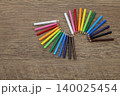 木のテーブルに並べた色鉛筆 colored pencils lined up on table 140025454
