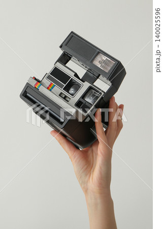 A hand holds a vintage camera ready to take a picture A hand holds a vintage camera ready to take a picture 140025596