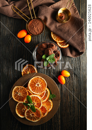 Sliced oranges, chocolate treats, and mint on a wooden table Sliced oranges, chocolate treats, and mint on a wooden table 140025628