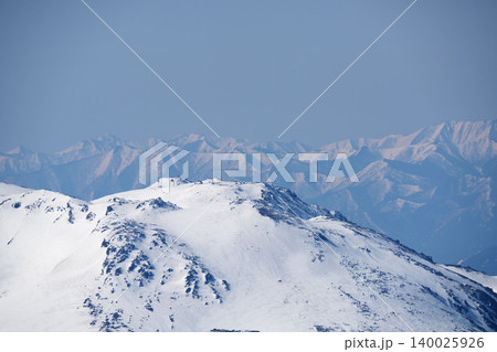 北海道大雪山の鋭い山頂と残雪の岩稜、ディテール、霞かかる青空、早春の山岳風景（3月） 140025926