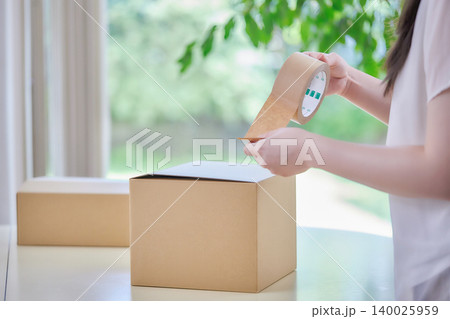 段ボール箱を作る若い女性 140025959