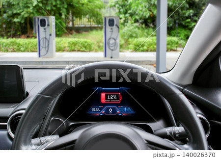 Modern electric vehicle dashboard displaying a low battery alert Modern electric vehicle dashboard displaying a low battery alert 140026370