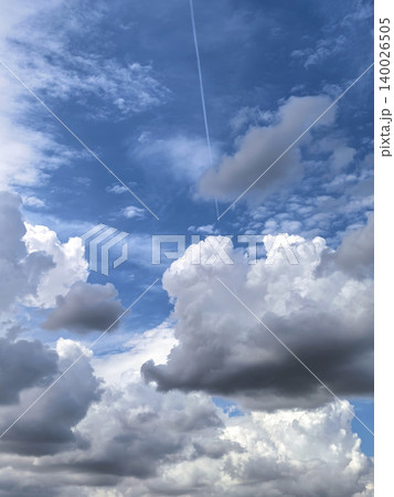 Dramatic Towering Clouds Beneath Bright Blue Sky 140026505