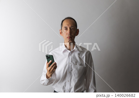 スマートフォンを持つ中高年日本人男性 スマートフォンを持つ中高年日本人男性 140026682