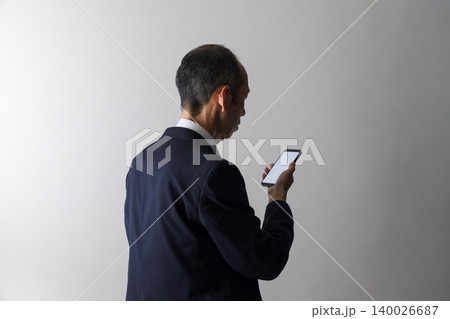 スマートフォンを見る中高年日本人男性 140026687