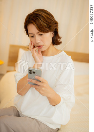 夜にスマホを見る女性 夜にスマホを見る女性 140027357