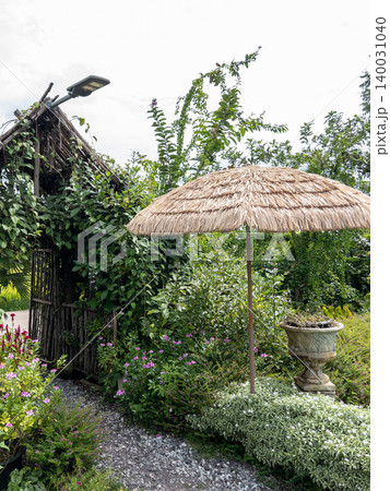 Rustic Tropical Garden With Thatched Umbrella And Wooden Arch 140031040