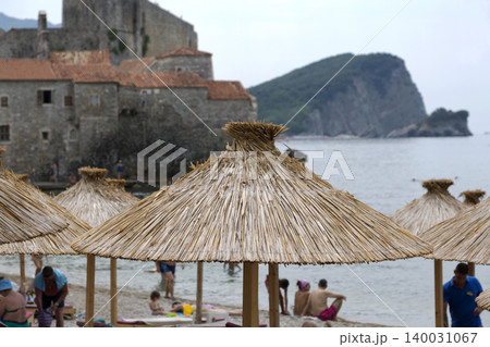 Budva, Montenegro - August 03, 2017:Sun umbrella from reeds on the beach of Budva, Montenegro. 140031067