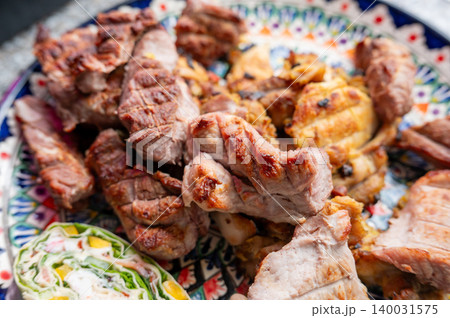 Grilled pork and chicken slices arranged on ceramic plate 140031575