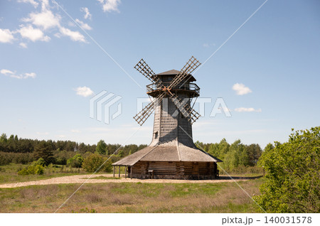 Rustic wooden windmill in countryside landscape with clear blue sky 140031578