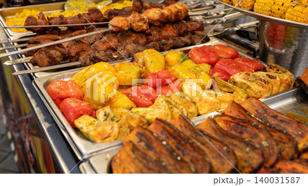 Grilled vegetables and meat skewers at a vibrant outdoor market 140031587