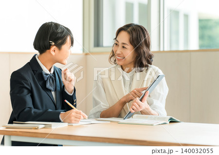 タブレットを使い勉強をする制服姿の小学生,中学生,高校生とママ,母親,教師,先生,講師 タブレットを使い勉強をする制服姿の小学生,中学生,高校生とママ,母親,教師,先生,講師 140032055