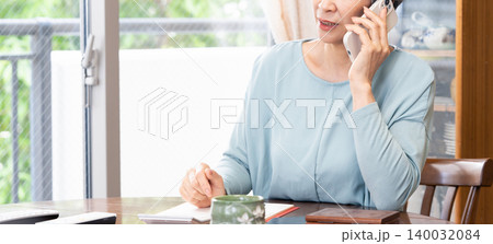 自宅でスマホ通話するシニア女性 自宅でスマホ通話するシニア女性 140032084