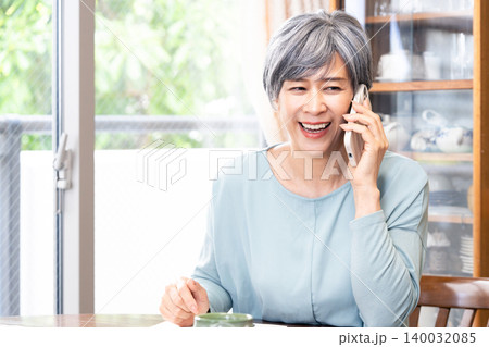 自宅でスマホ通話するシニア女性 140032085