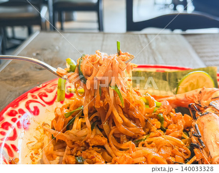 米粉麺料理のパッタイ。もやしとニラや唐辛子を混ぜて食べるタイ風の焼きそば。フォークで持ち上げている 140033328