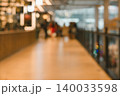 Blurred shopping mall corridor with warm bokeh lights and people walking on walkway abstract background 140033598
