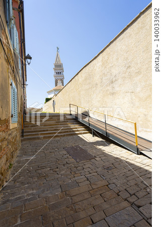 A stone paved alleyway leads upwards towards a distant bell tower in Piran, Slovenia A stone paved alleyway leads upwards towards a distant bell tower in Piran, Slovenia 140033962