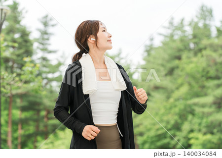 イヤホンをして公園でランニング,ウォーキング,ジョギング,運動をする女性(ダイエット,スポーツ) イヤホンをして公園でランニング,ウォーキング,ジョギング,運動をする女性(ダイエット,スポーツ) 140034084