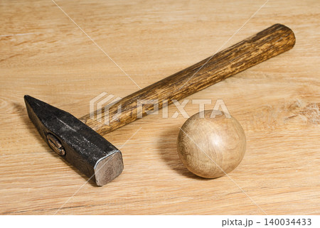 Hammer and wooden ball on a wooden surface Hammer and wooden ball on a wooden surface 140034433